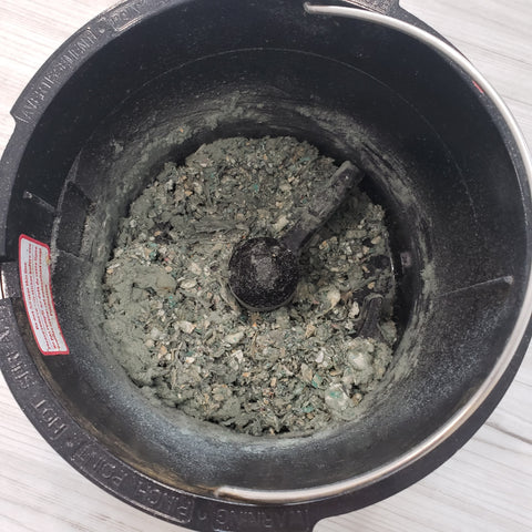 Black bucket containing decomposed bioplastics with dirt-like consistency