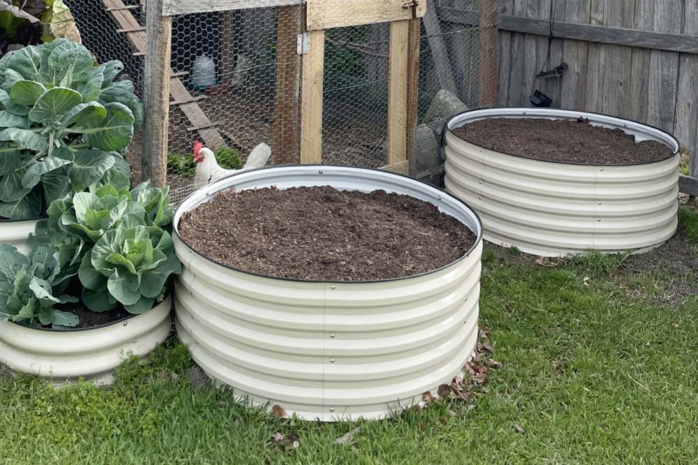 round metal raised beds placed on the grass