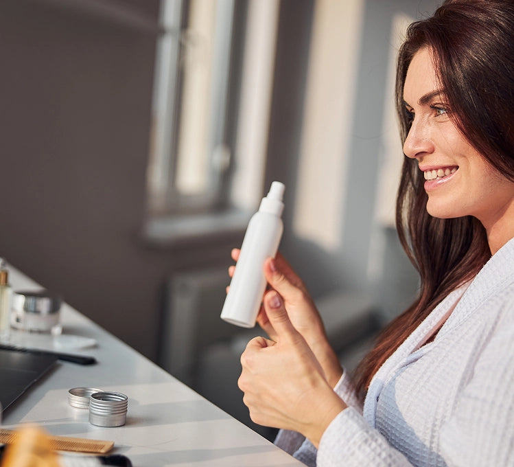 Woman holding a spray bottle in a kitchen setting - e11ement