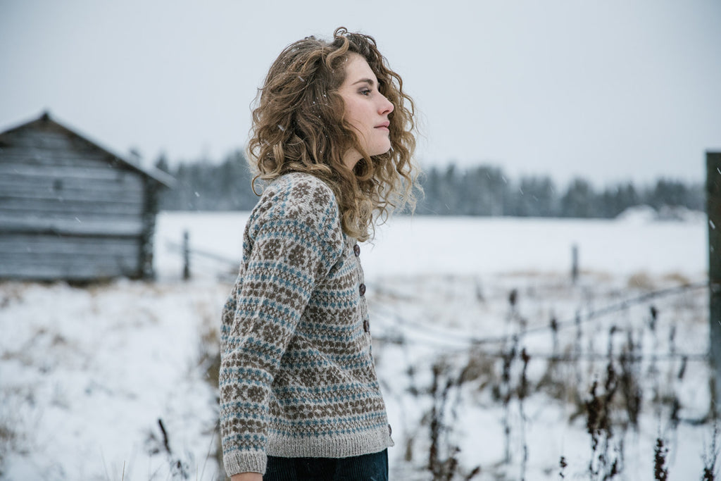 Image of the Marit cardigan, worn by a model in a wintery scene.