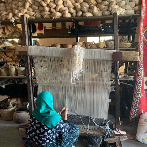 a woman weaving a berber carpet