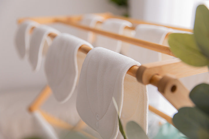 cloth nappy inserts drying on wooden rack