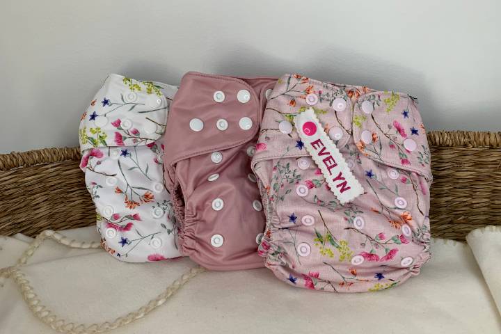 Pink and floral cloth nappies labeled ready for daycare