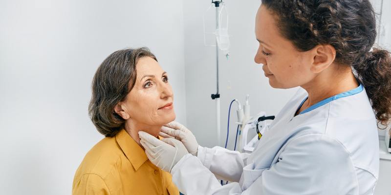 doctor checking thyroid