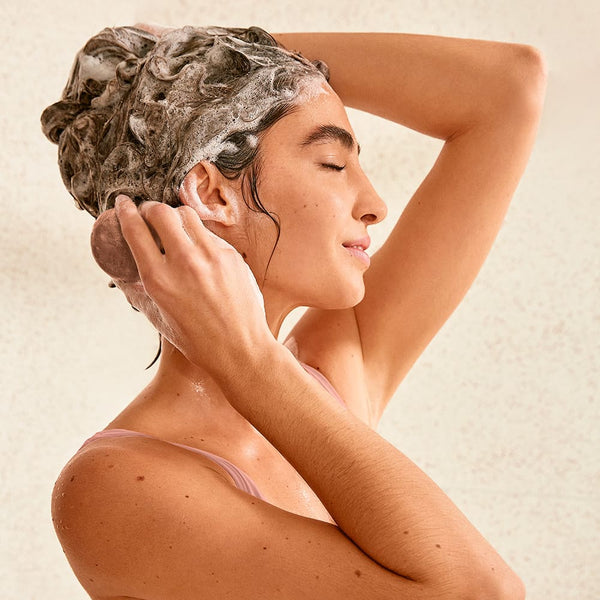 Girl applying shampoo bar on her hair