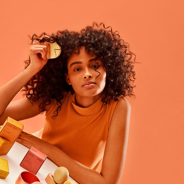 Girl holding the Curl Definer & Leave-in Conditioner Bar