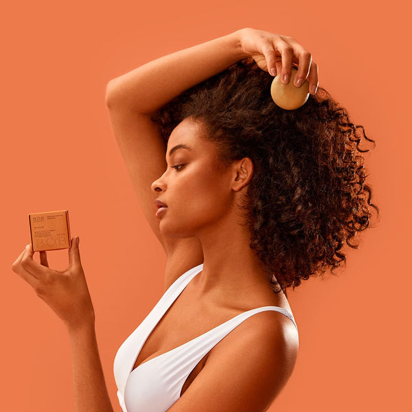 Girl holding the Moisturizing Shampoo Bar closer to her hair