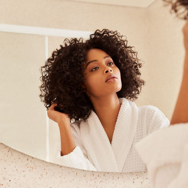 Girl looking at the mirror playing with her hair