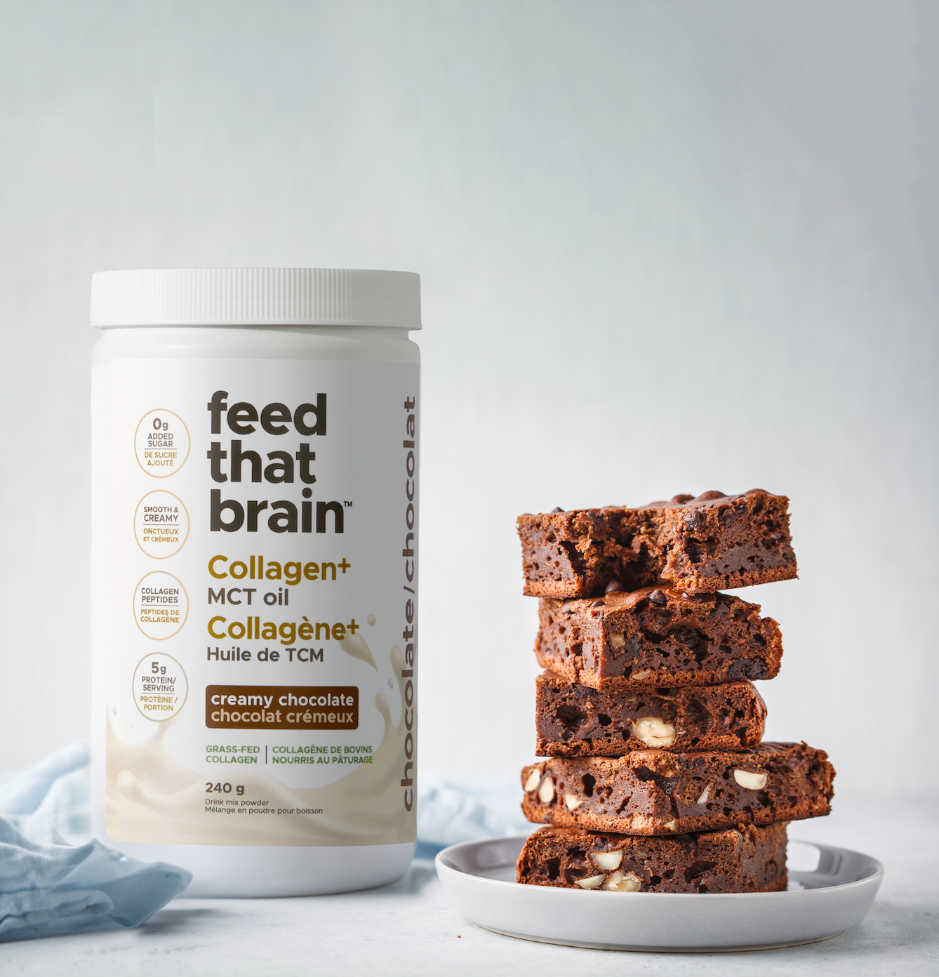 Pita brain, chocolate premium collagen  MCT Oil powder, standing next to decadent, delicious brownies with nuts against a white backdrop
