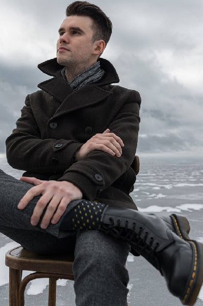 men sitting in chair wearing black jacket ,black pen and Ankle Length Boots