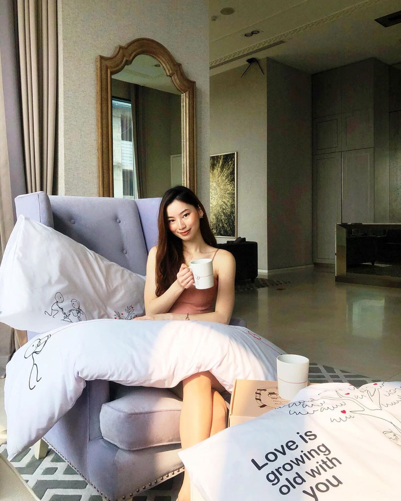 Eine schöne Dame sitzt in einem schönen Wohnzimmer mit einer Sammlung süßer Kissen