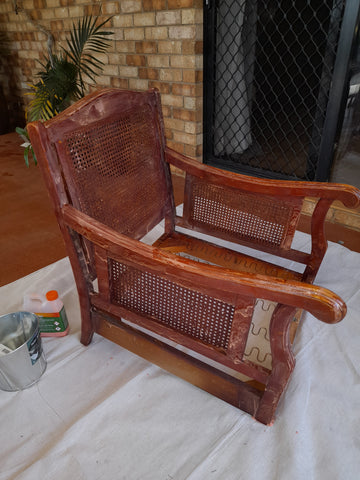 Single timber & rattan armchair covered in paint stripper