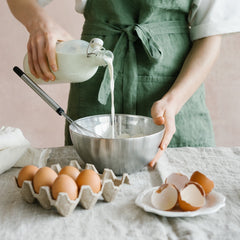 Pouring 1 cup of milk into the self raising flour & egg prior to whisking while making Luxe & Humbles' 3 ingredient pancakes.
