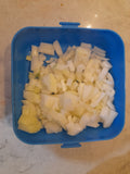 500g onions diced in a blue Tupperware container and sprinkled with salt.