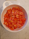 1.5kgs of chopped tomato's in a white Tupperware bowl sprinkled with salt. 
