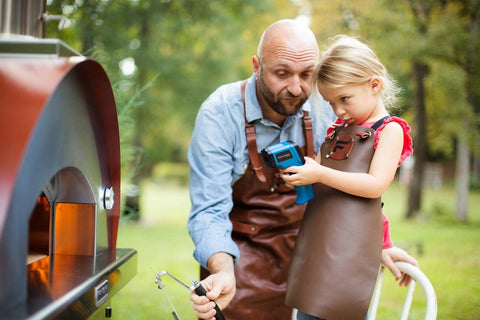 Man helping a child check the temperature of a Fontana Forni pizza oven