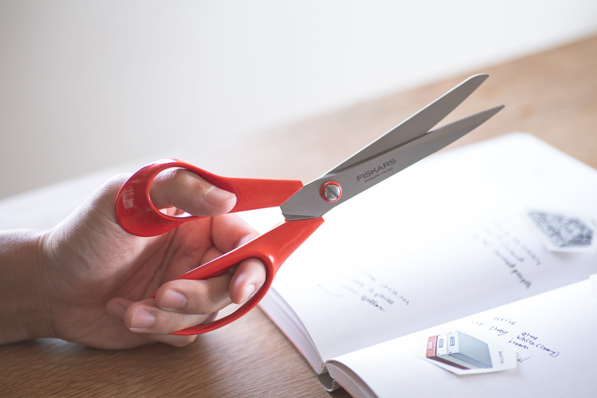 Left-handed red scissors being held in the left hand