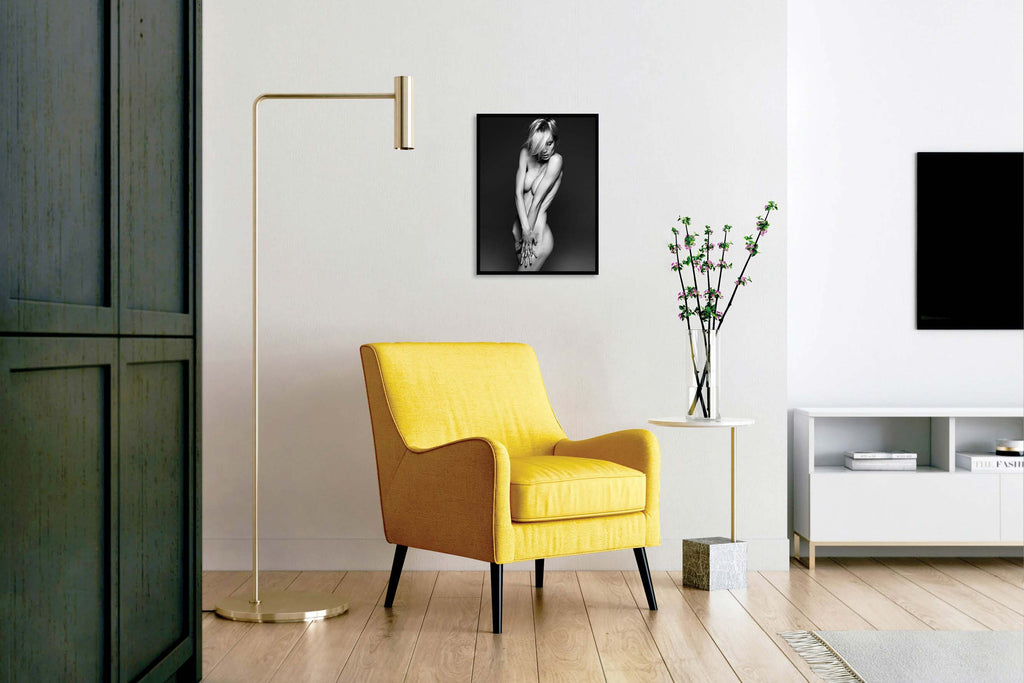 An limited edition print of a sensual nude hanging above a chair in the living room by Gianluca Fontana