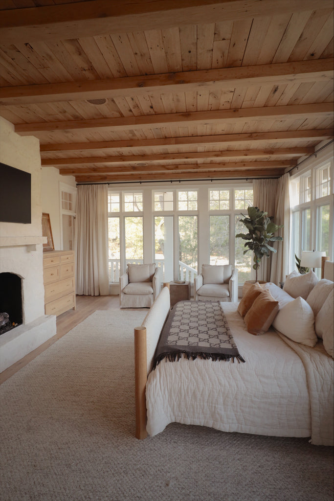 cabin inspired primary bedroom with stone fireplace