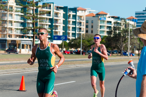 Triathletes running sweating on road in race