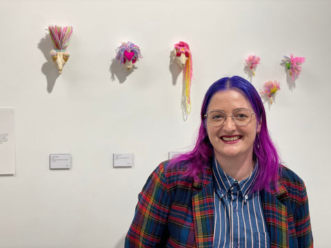 Cindy Walter stands in front of knitted skull sculptures exhibited at The Collaboration New Plymouth