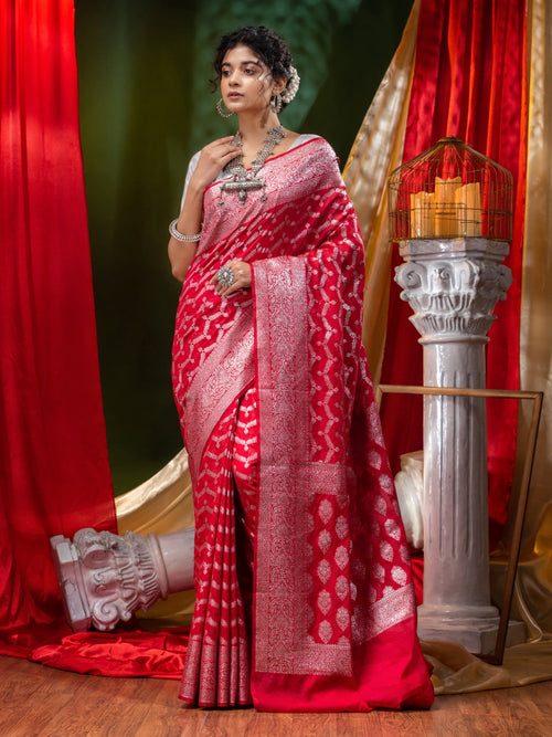 A red Kanchipuram silk saree with a fine silver zari work in columns of  peacocks and deers all over. This beautiful saree also has a gracious pallu  with waves, …