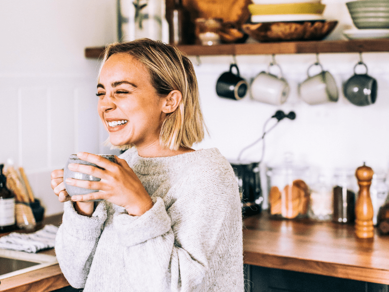 Woman smiling and enjoying a cup of oolong tea