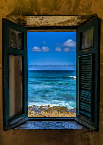 An old window overlooking the ocean in San Juan Puerto Rico