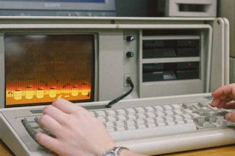 A woman using an old computer.