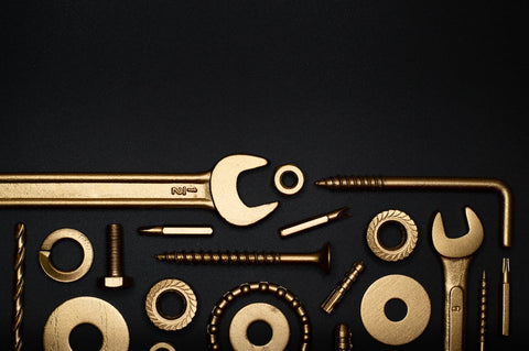 Golden colored tools on a black background.