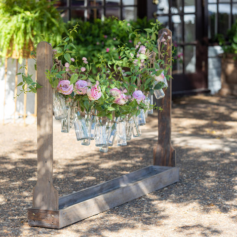 Create a festive display of freshly cut blooms for special events and gatherings with this bottle vase garland and wooden station.