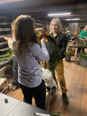 women helping each other with wreaths