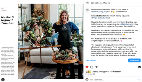 happy florist in blue jumper with wreath on instagram