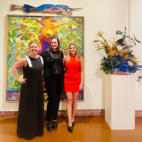 three women in luxury gowns fashion at museum of art preview with flowers