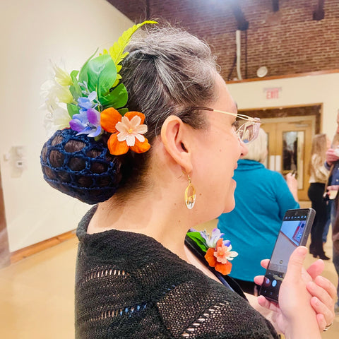 colorful felt flower hair accessories on older woman at museum of art in bloom