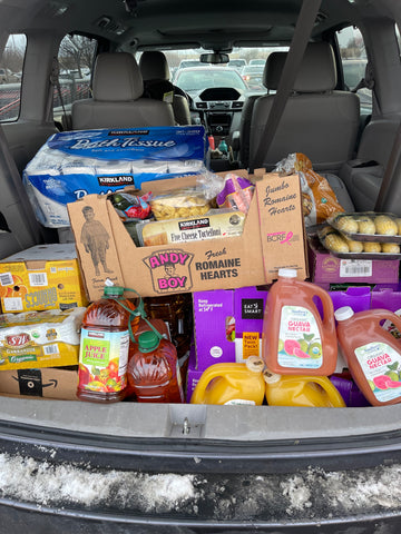 The trunk of a minivan filled with groceries of all kinds