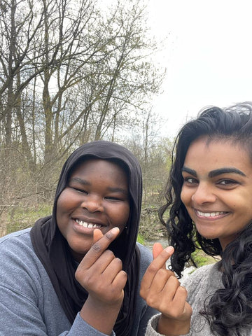 picture of hannah and halima smiling outdoors on one of their "hikes"
