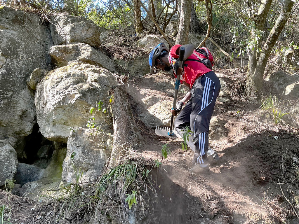 A Kijabe MTB volunteer works on a local trail in Kijabe, Kenya