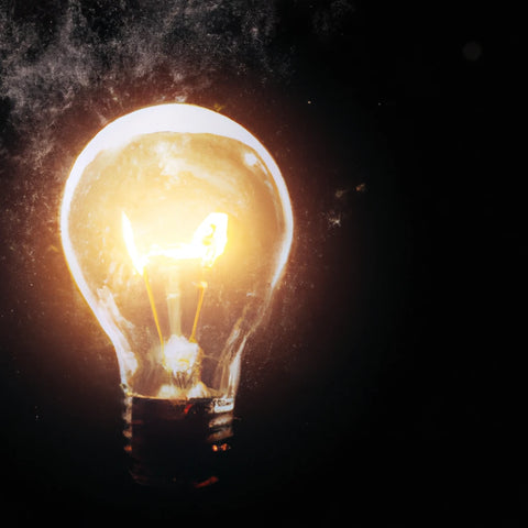lightbulb consuming energy in dark background