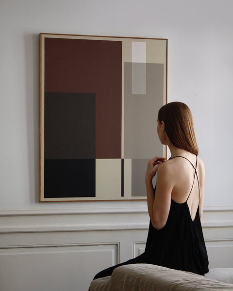 Arist looking at her own art piece, having her back showing in a beautiful black silk dress