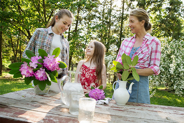 mom and daughters arranging flowers on Mother’s Day