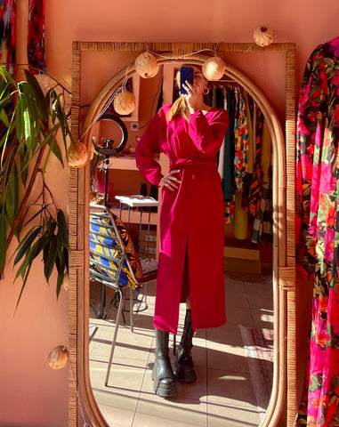 woman with fuchsia dress in front of a mirror