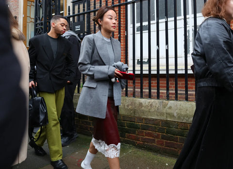 woman with grey blazer, burgundy skirt with lace detail and white socks