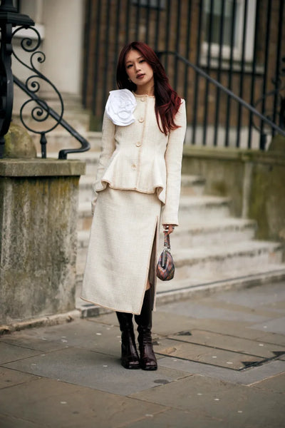 woman with ecru blazer, skirt and a flower detail