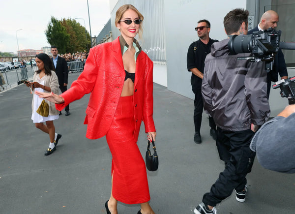 woman in red blazer, red skirt and black bra