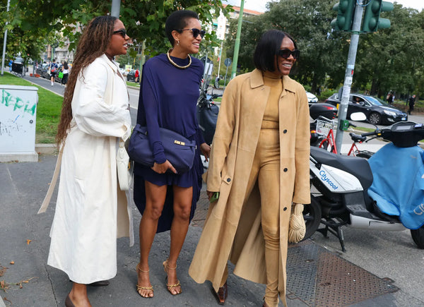 three women with purple outfit standing out