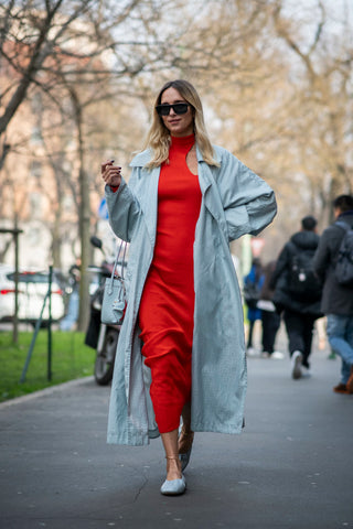 woman with red dress and baby blue overcoat and ballerina flats