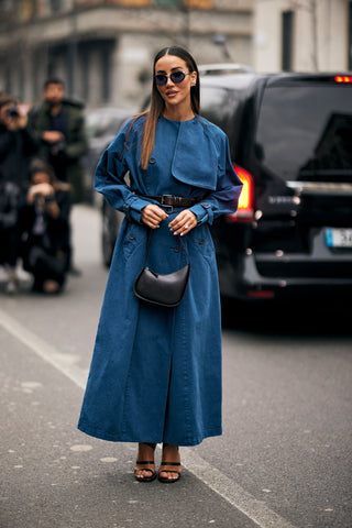 woman with long brown hair wearing a denim overcoat as a dress
