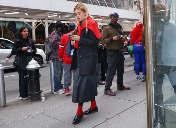 woman in grey outfit with red details