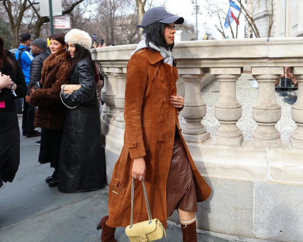 woman with suede brown coat and jockey hat